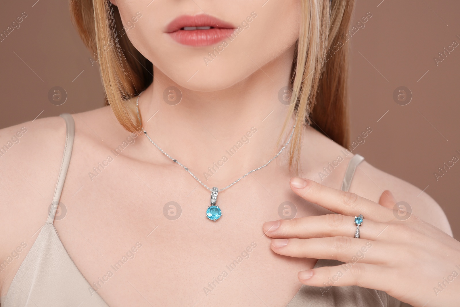 Photo of Woman with elegant jewelry on light brown background, closeup