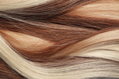 Photo of Strands of different color hair as background, closeup