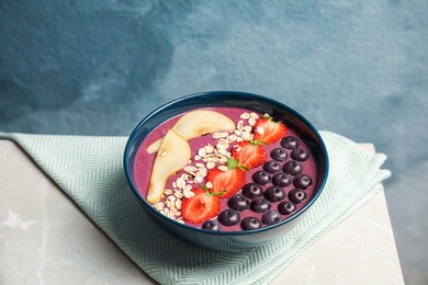 Photo of Bowl with tasty acai smoothie on gray table