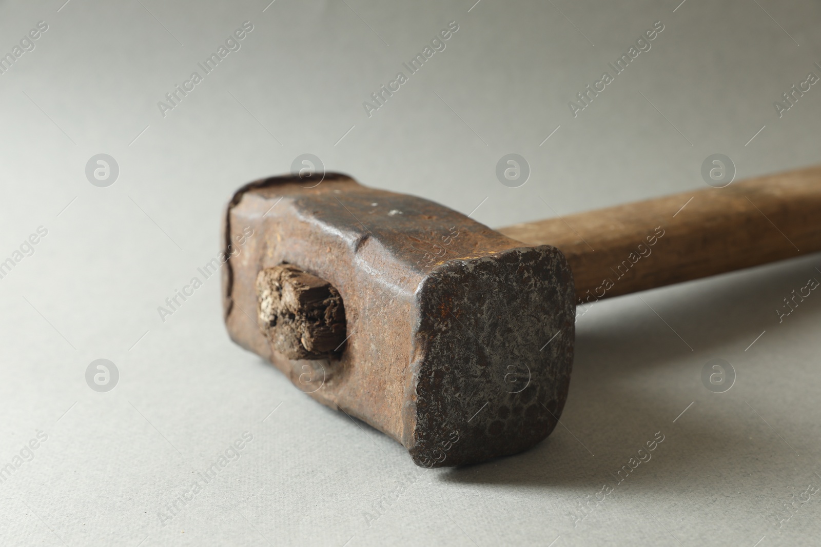 Photo of One old sledgehammer on grey background, closeup