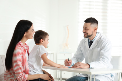 Photo of Little boy with mother visiting orthopedist at clinic