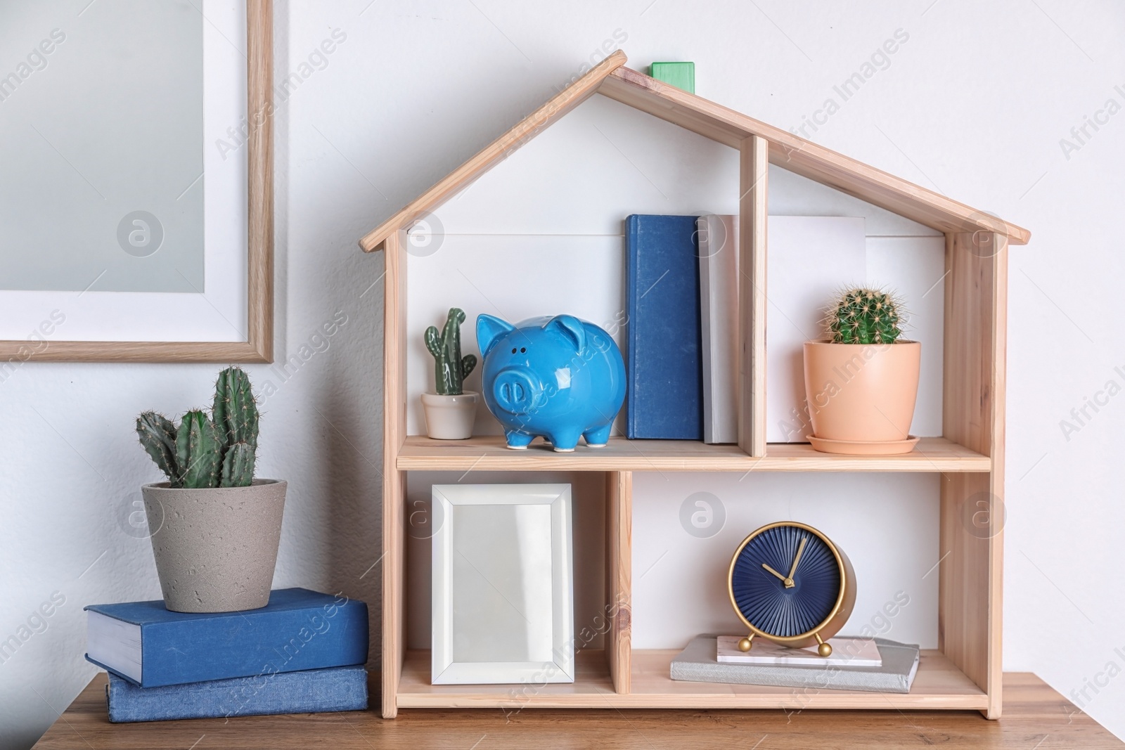 Photo of Color piggy bank on shelf near wall. Cute interior element