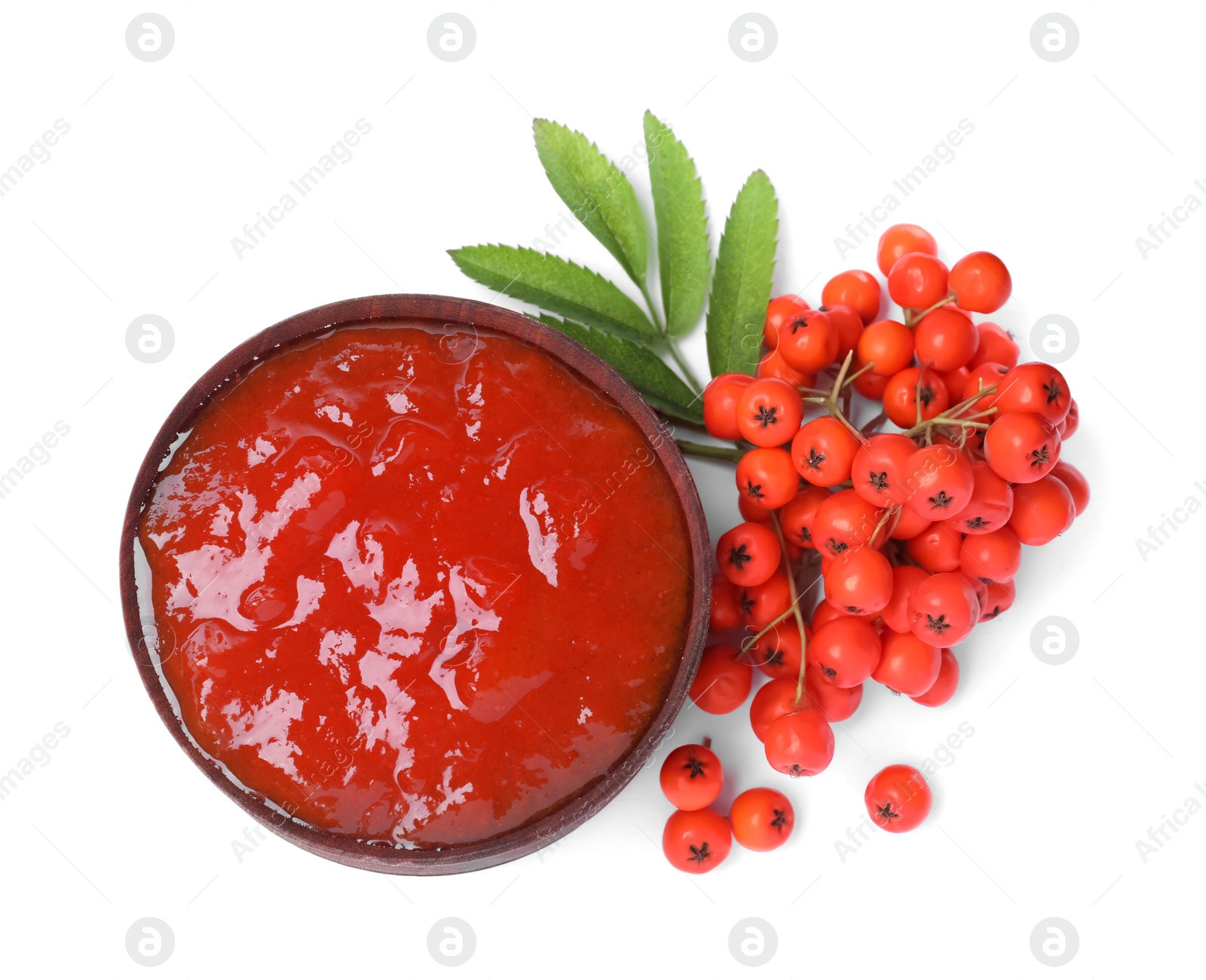 Photo of Delicious rowan jam in bowl and berries on white background, top view