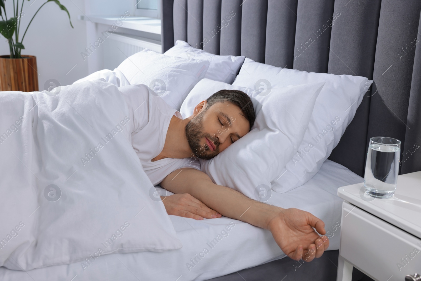 Photo of Handsome man sleeping in soft bed at home