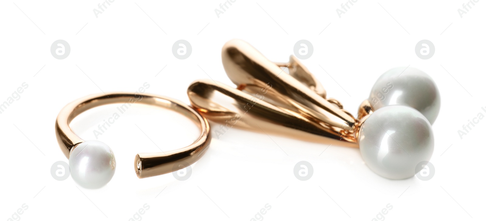 Photo of Elegant golden ring and earrings with pearls on white background