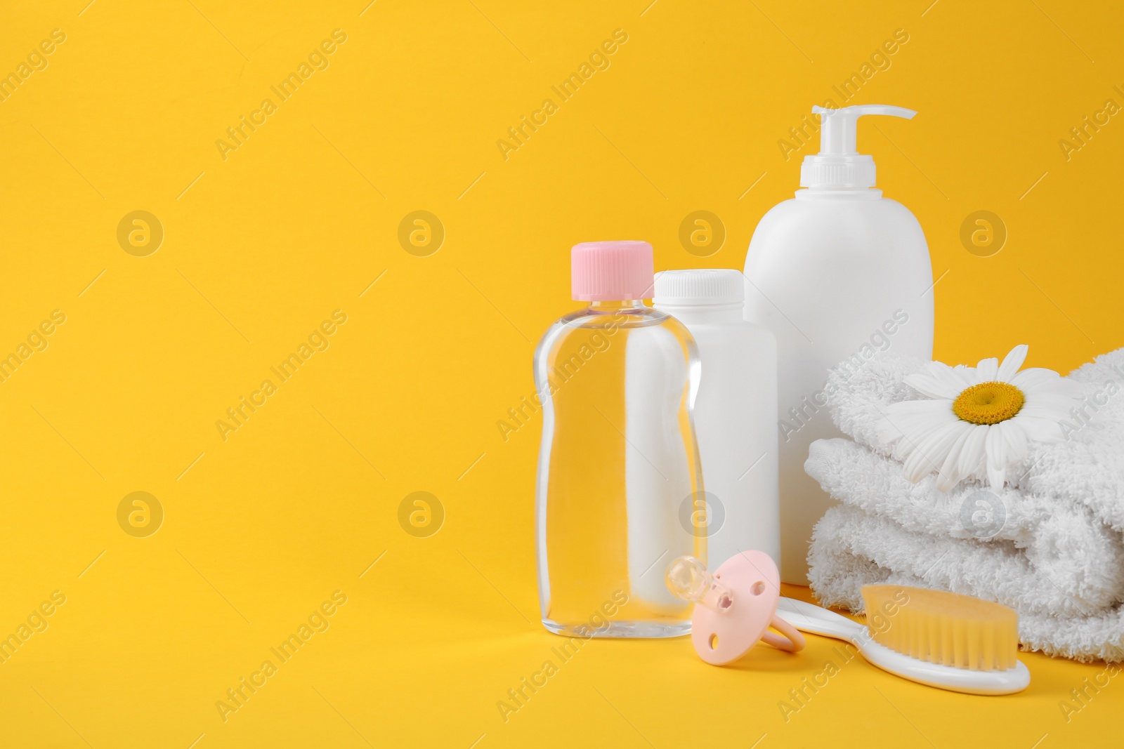 Photo of Different skin care products for baby and accessories on yellow background. Space for text