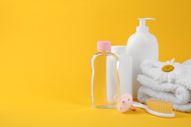 Photo of Different skin care products for baby and accessories on yellow background. Space for text