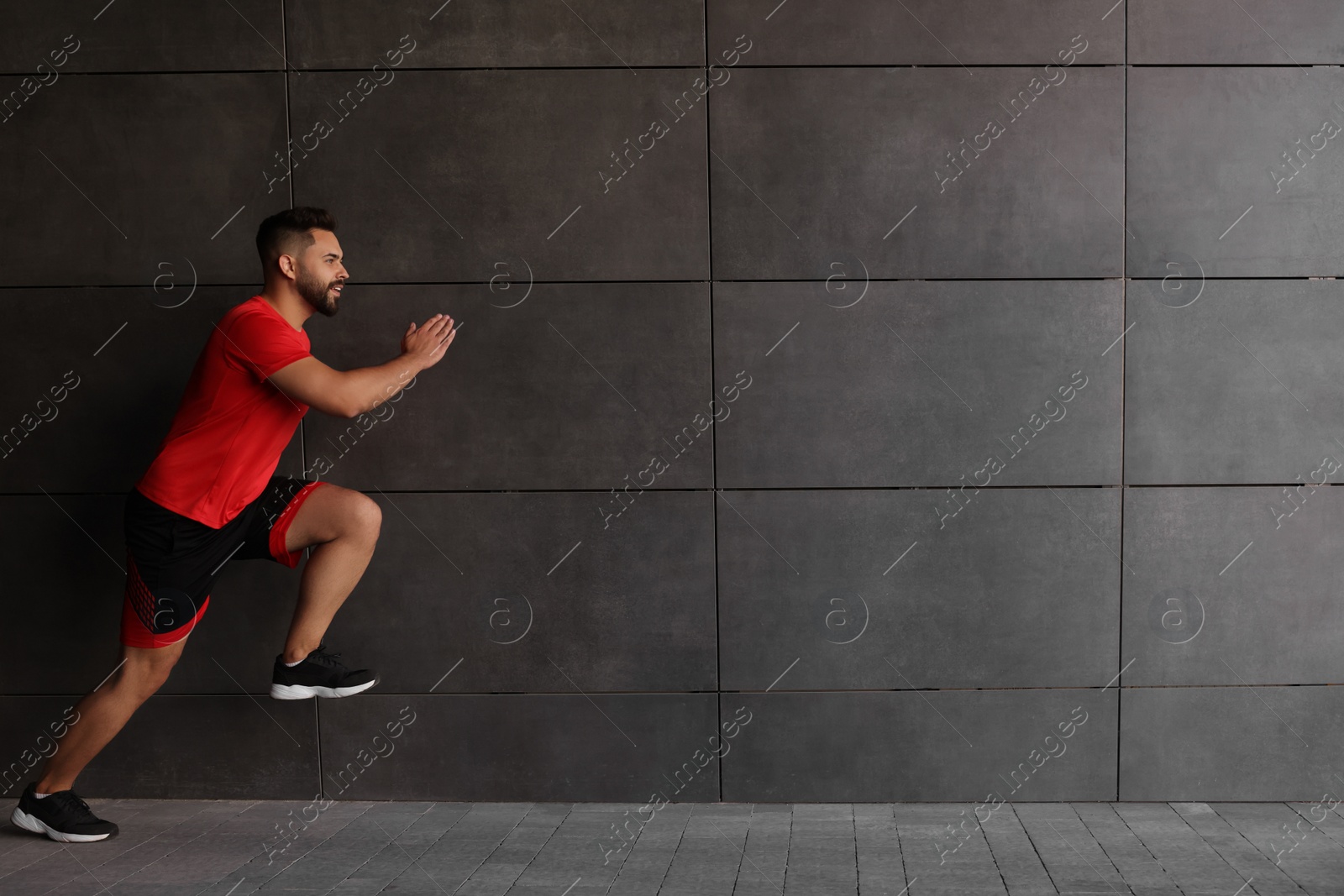 Photo of Young man running near building outdoors. Space for text