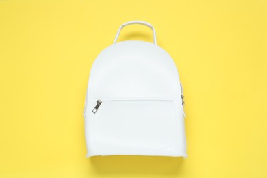 Photo of Stylish urban backpack on yellow background, top view