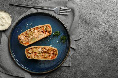 Pieces of delicious strudel with chicken and vegetables served on grey textured table, flat lay. Space for text