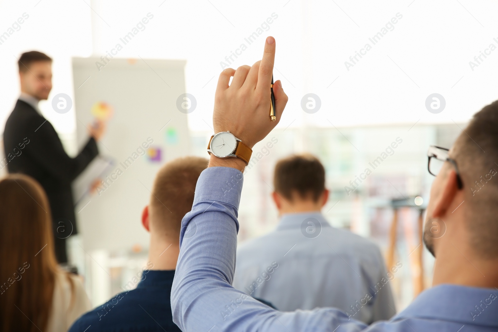 Photo of Man raising hand to ask question at business training indoors, closeup