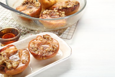 Photo of Delicious quinces baked with honey and walnuts on white table