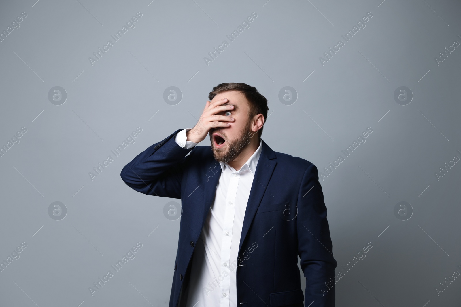 Photo of Young businessman feeling fear on grey background