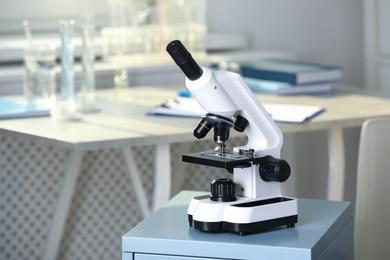 Photo of Modern medical microscope on drawer in laboratory, space for text
