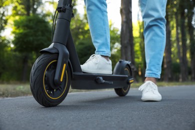 Photo of Man with modern electric kick scooter in park, closeup