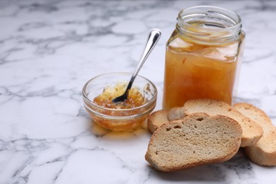 Photo of Hard chuck crackers and jam on white marble table. Space for text