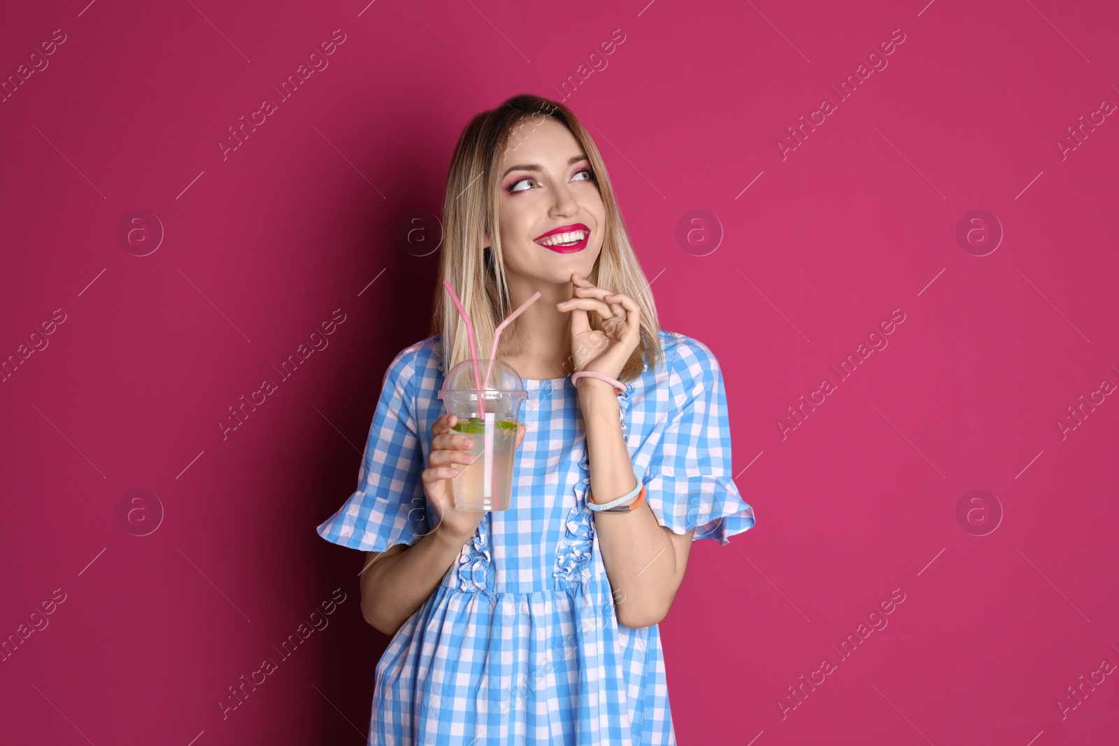 Photo of Young woman with tasty lemonade on color background. Natural detox drink