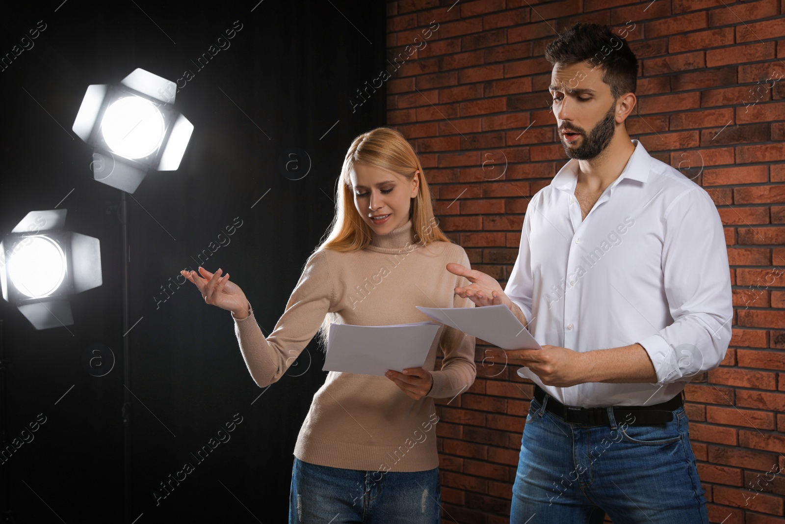 Photo of Professional actors reading their scripts during rehearsal in theatre