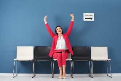 Photo of Young woman being happy after success job interview, indoors