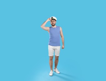 Full length portrait of sailor on light blue background