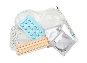 Contraceptive pills, condoms and thermometer isolated on white, top view. Different birth control methods