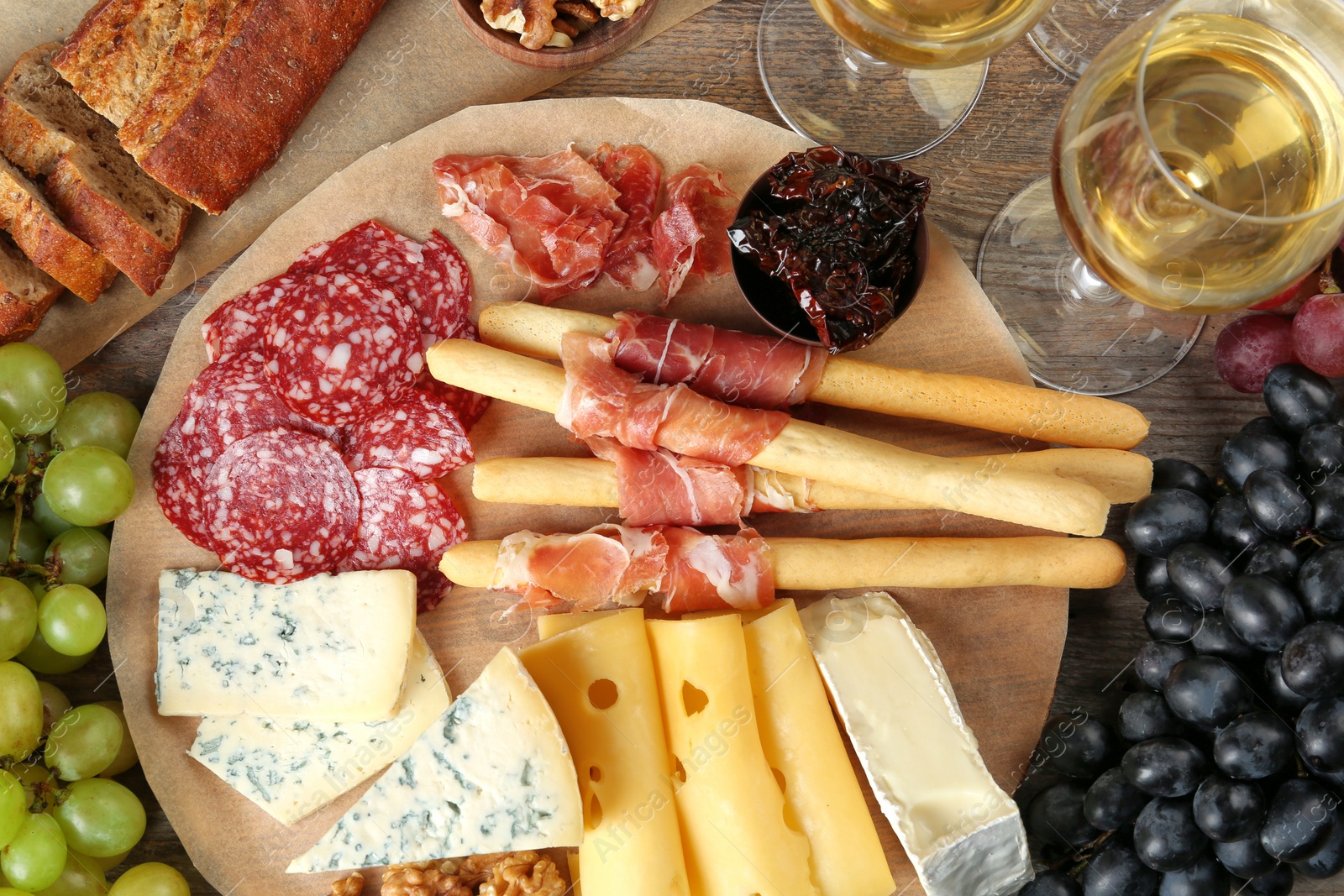 Photo of Flat lay composition with wine and snacks on wooden background