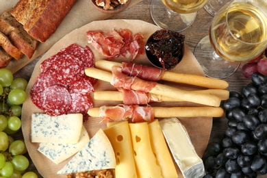 Flat lay composition with wine and snacks on wooden background