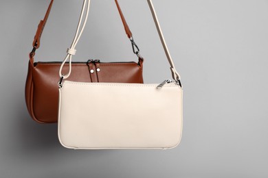 Different stylish woman's bags on light grey background