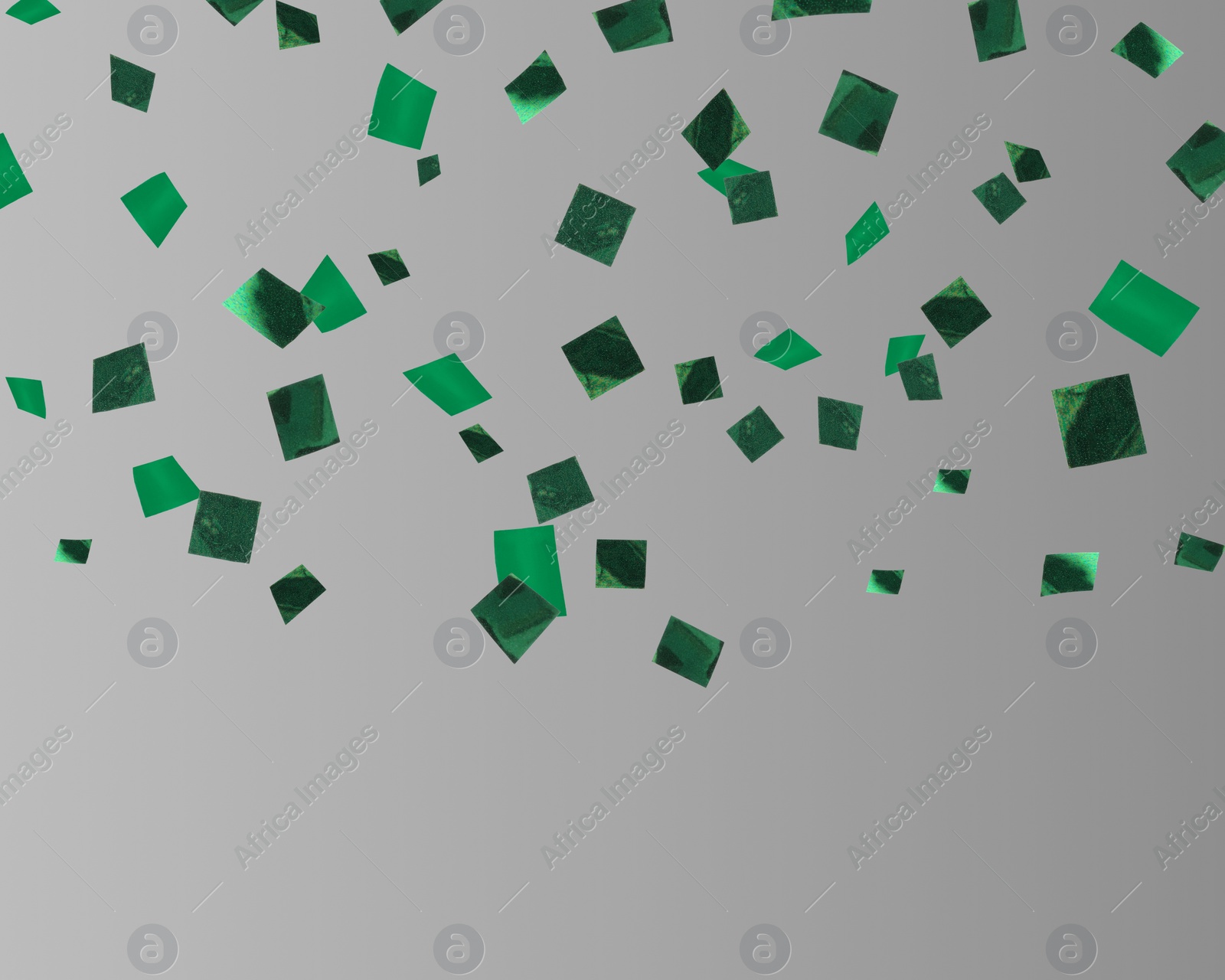 Image of Shiny green confetti falling on grey background