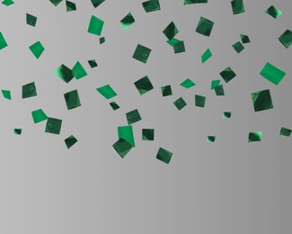 Shiny green confetti falling on grey background