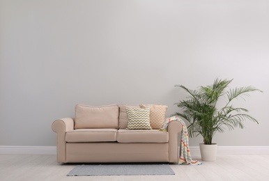 Photo of Simple room interior with comfortable beige sofa, space for text