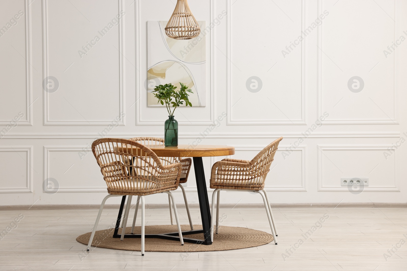 Photo of Dining room interior with comfortable furniture and green branches