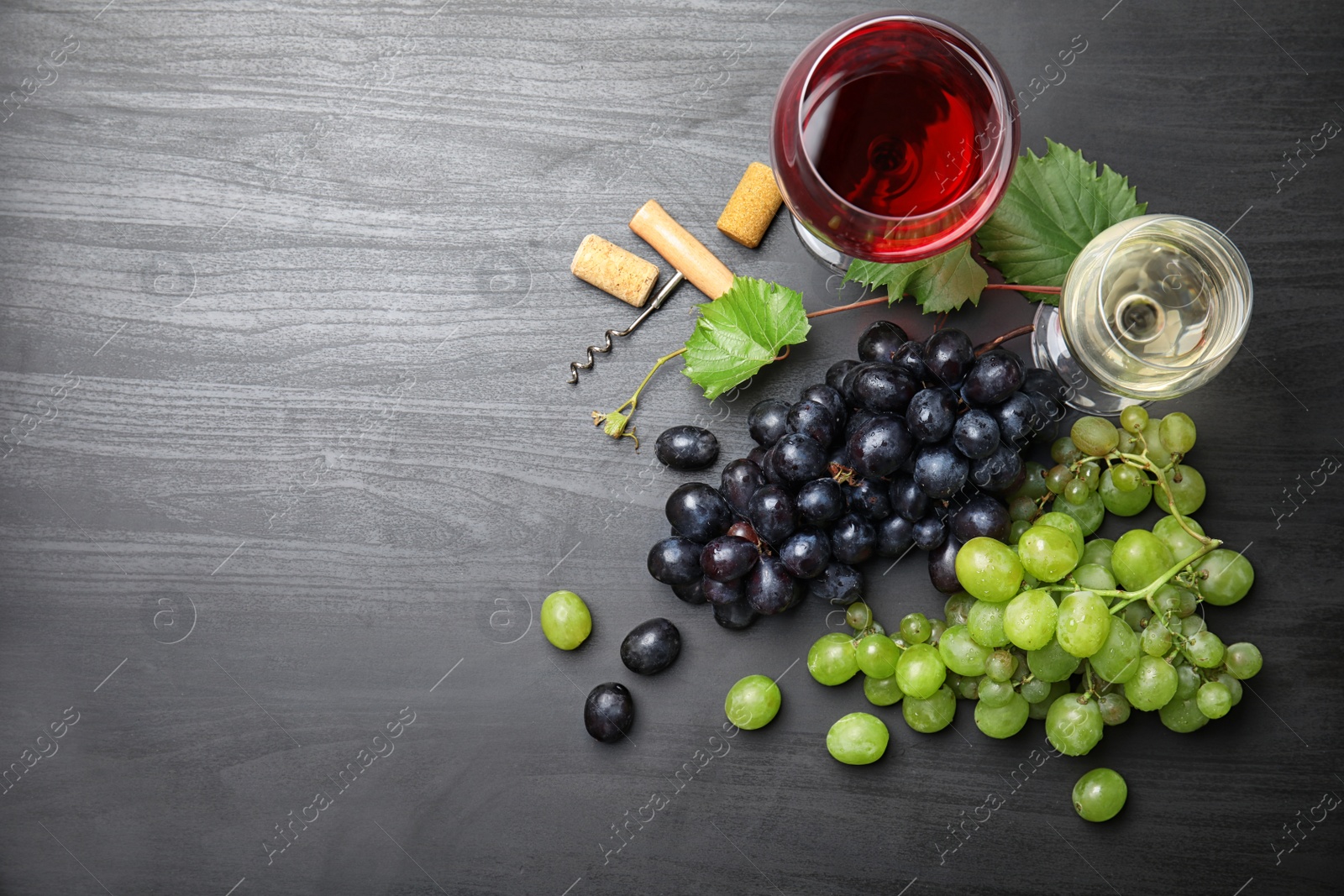 Photo of Flat lay composition with fresh ripe juicy grapes and space for text on wooden background