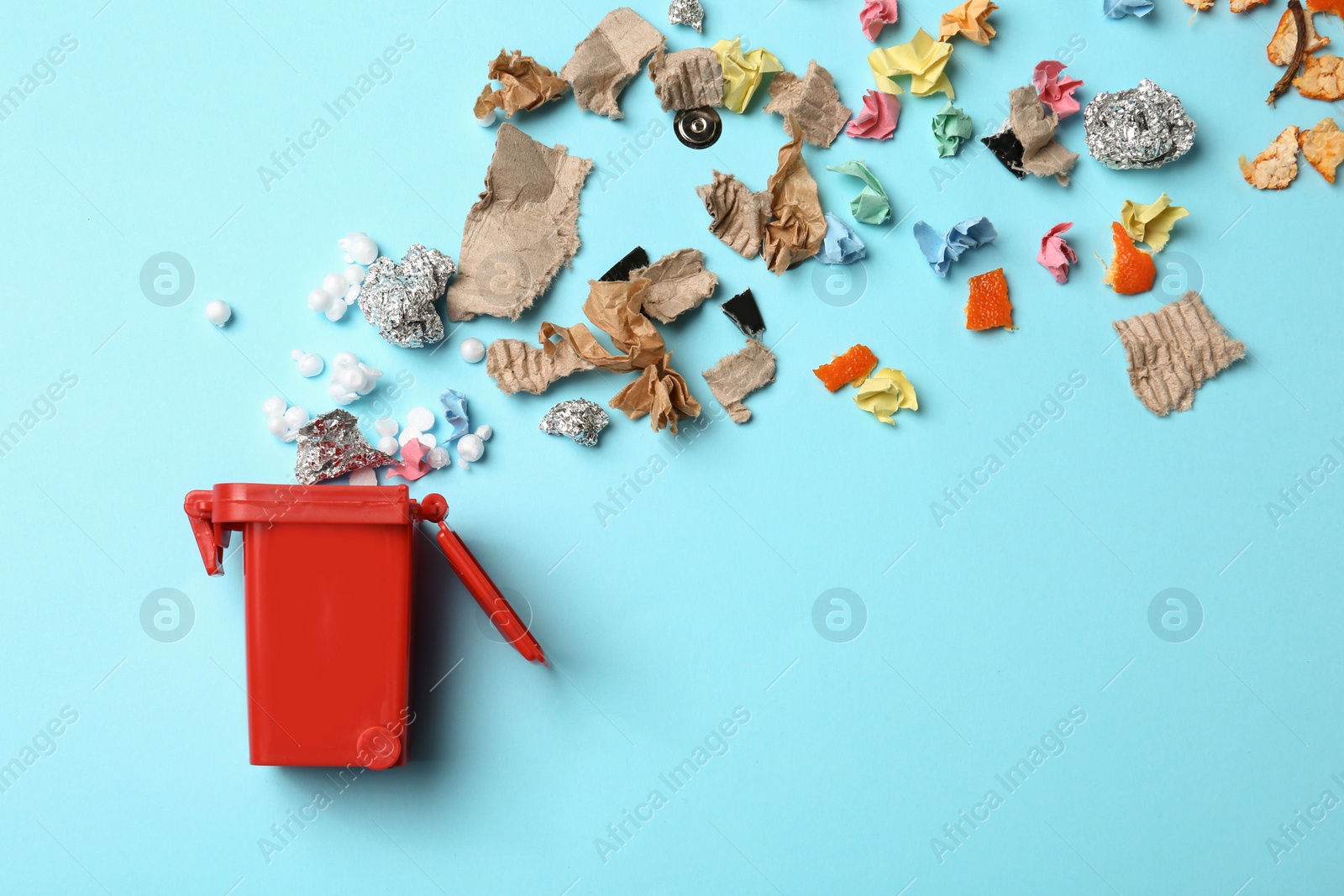 Photo of Trash bin and different garbage on color background, top view with space for text. Waste recycling concept