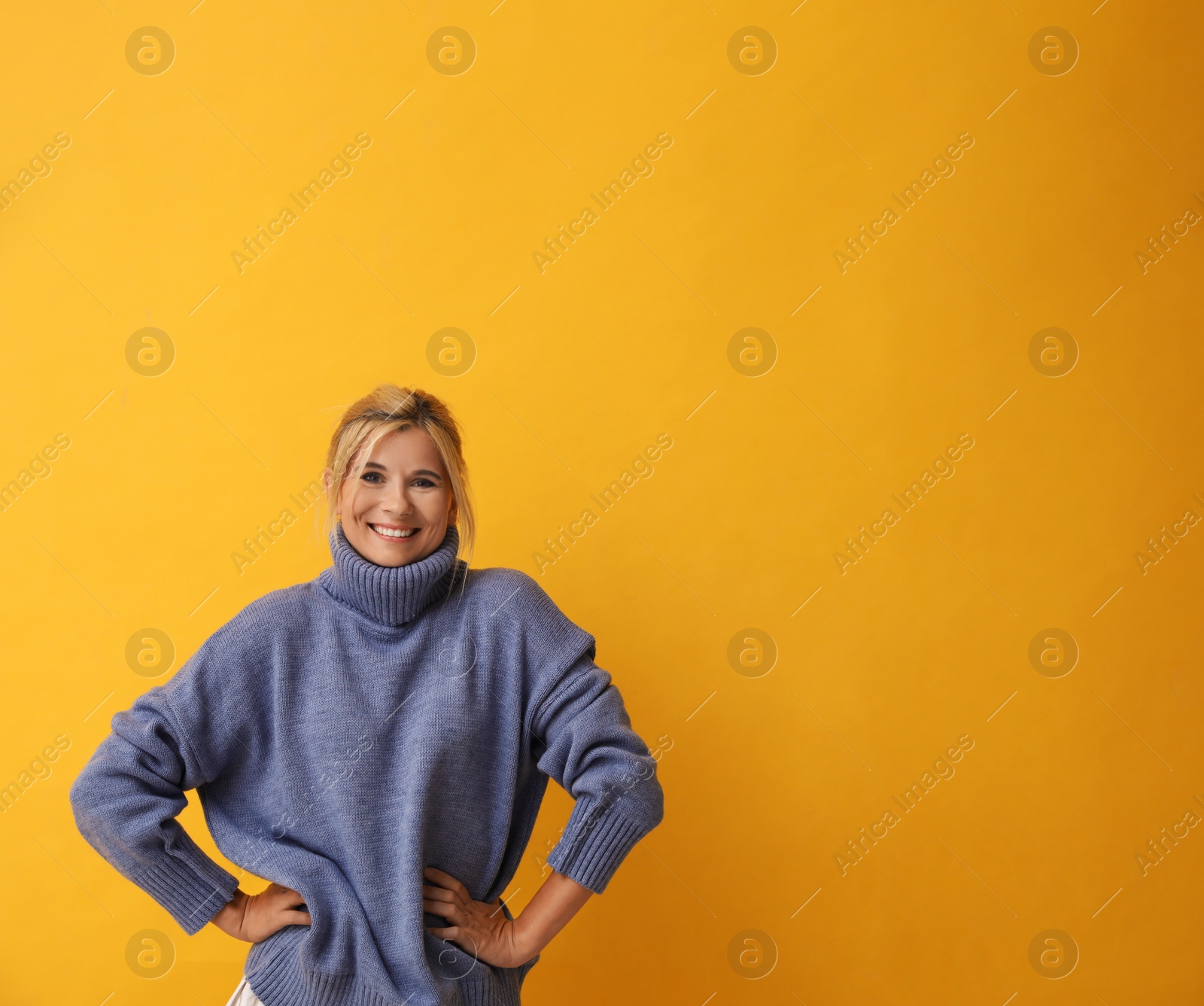 Photo of Happy woman in stylish sweater on yellow background. Space for text