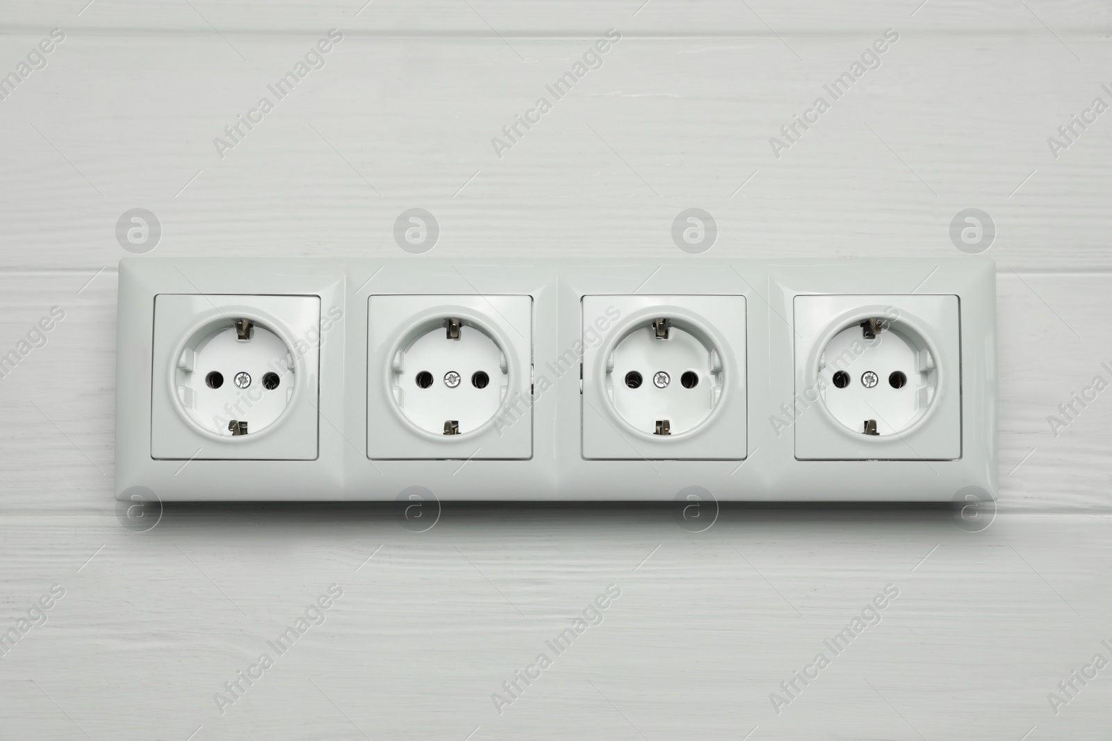 Photo of Modern plastic power socket on white wooden table, top view