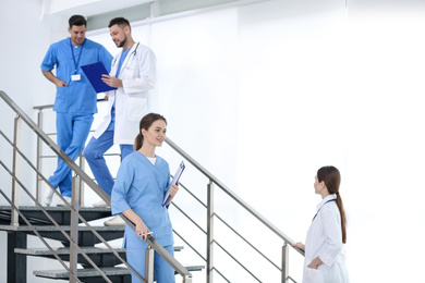 Photo of Team of professional doctors on staircase in clinic