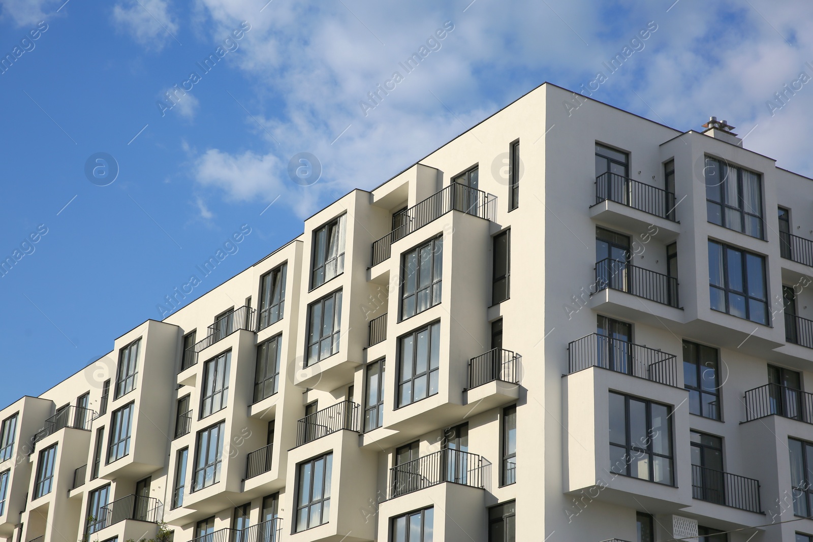 Photo of Modern building with big windows against blue sky outdoors