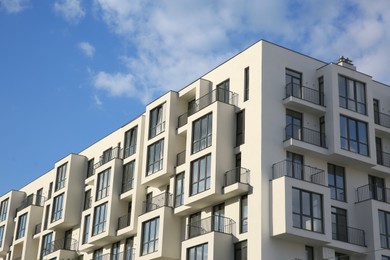 Photo of Modern building with big windows against blue sky outdoors