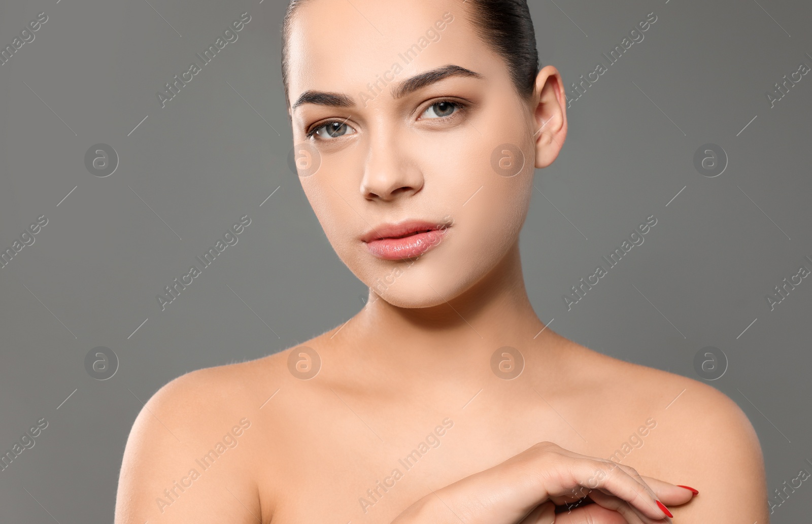 Photo of Portrait of young woman with beautiful face and natural makeup on color background