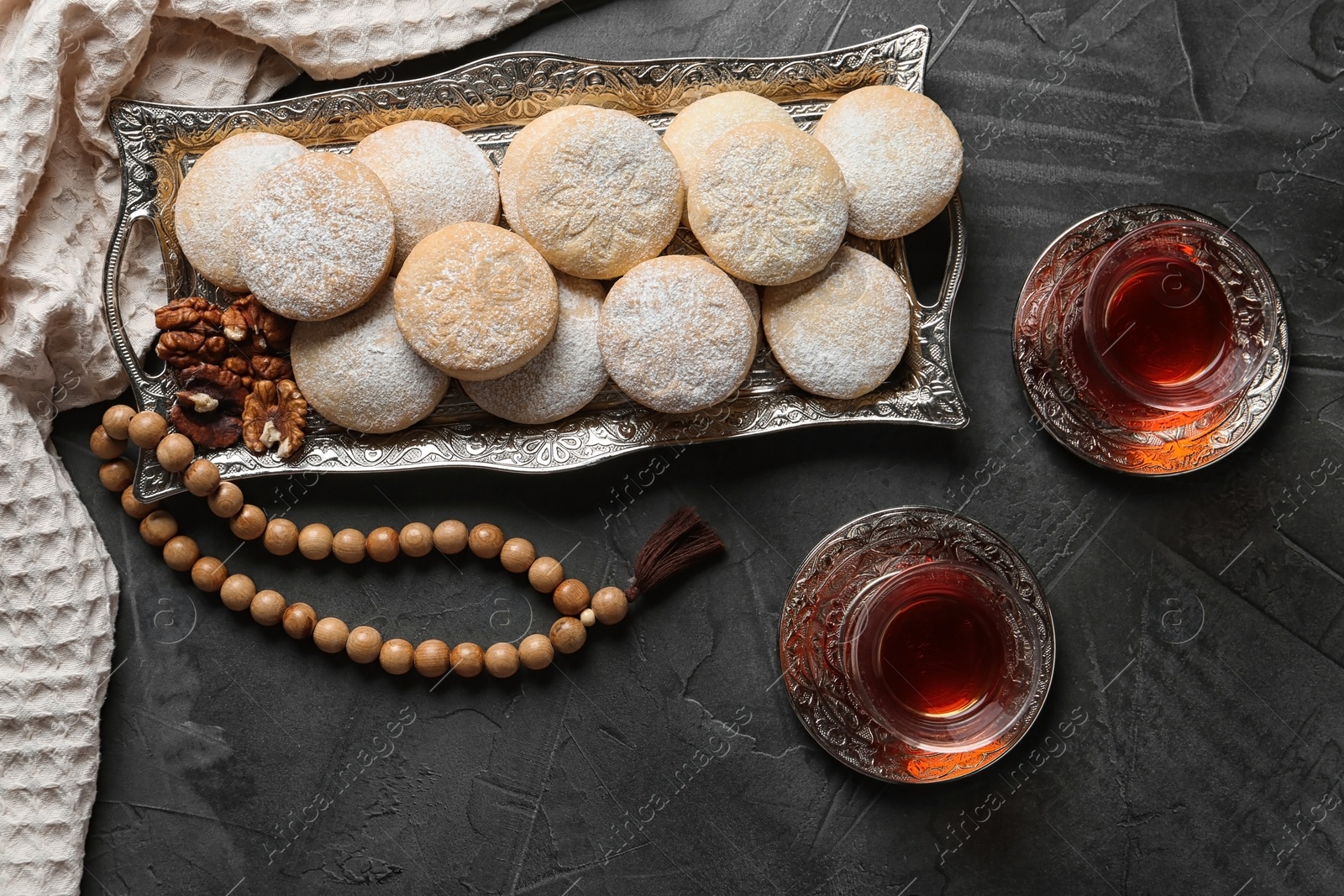 Photo of Flat lay composition with tray of traditional cookies for Islamic holidays on table. Eid Mubarak