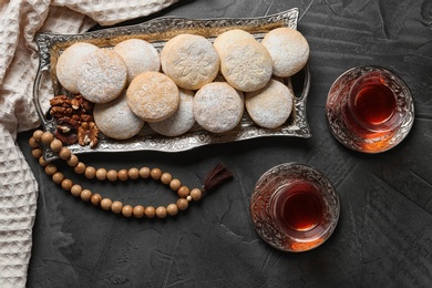 Flat lay composition with tray of traditional cookies for Islamic holidays on table. Eid Mubarak