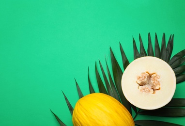 Photo of Composition with ripe tasty melons on green background, flat lay. Space for text
