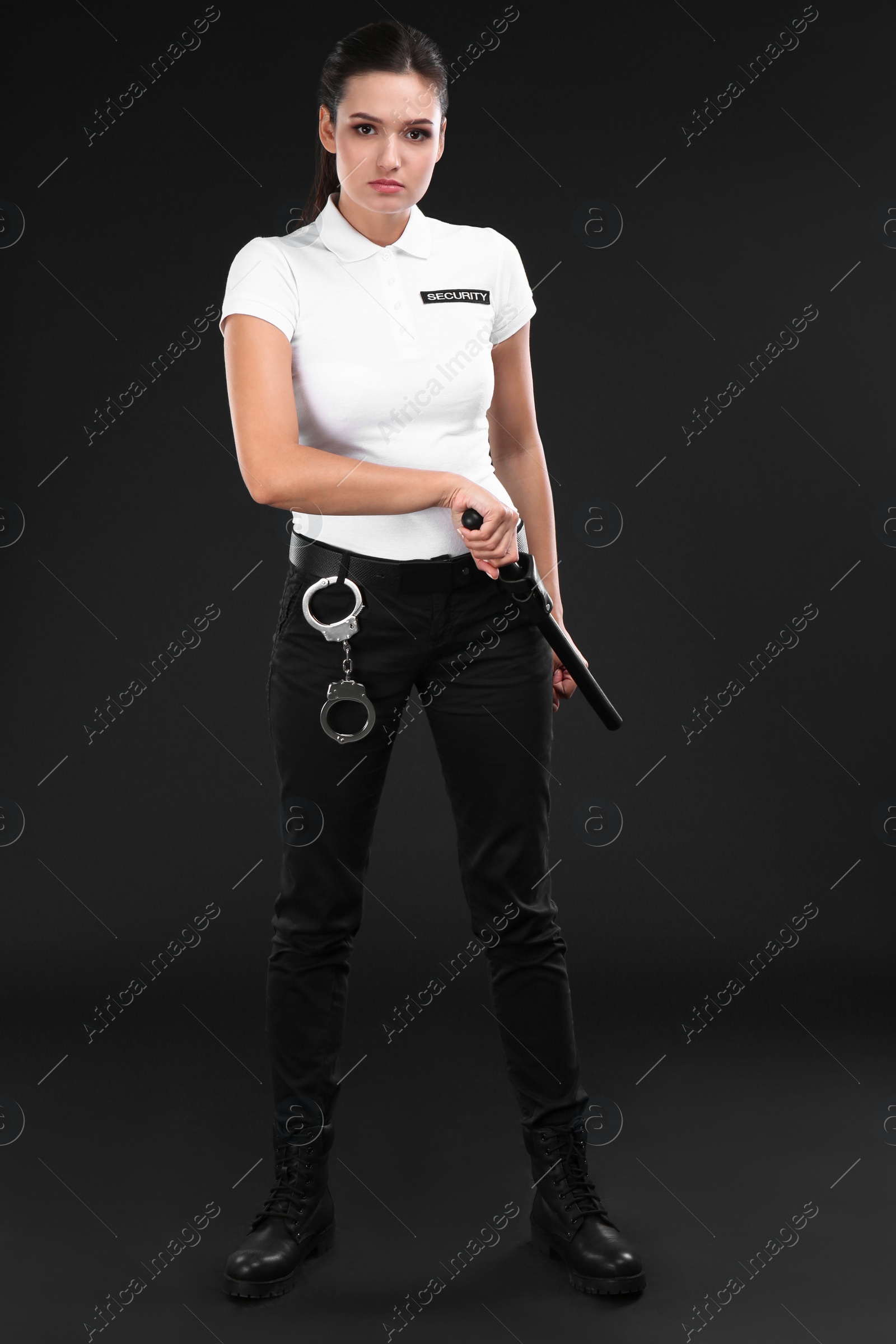 Photo of Female security guard with police baton on dark background