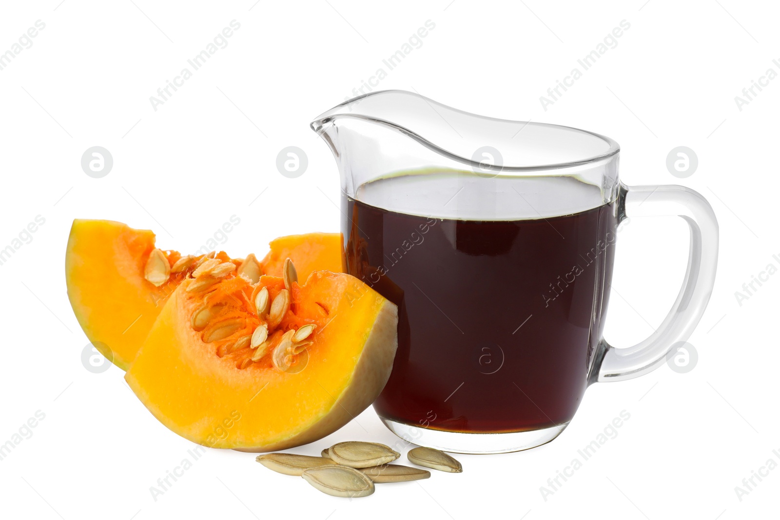 Photo of Fresh pumpkin seed oil in glass pitcher isolated on white