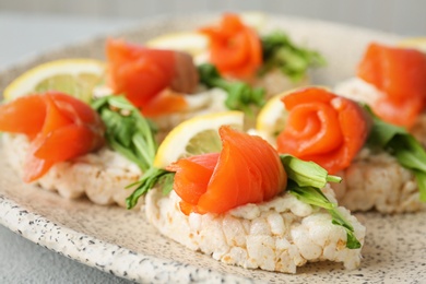 Photo of Crispbreads with fresh sliced salmon fillet on plate, closeup