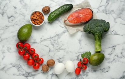 Frame of different fresh products on white marble table, flat lay with space for text. Keto diet