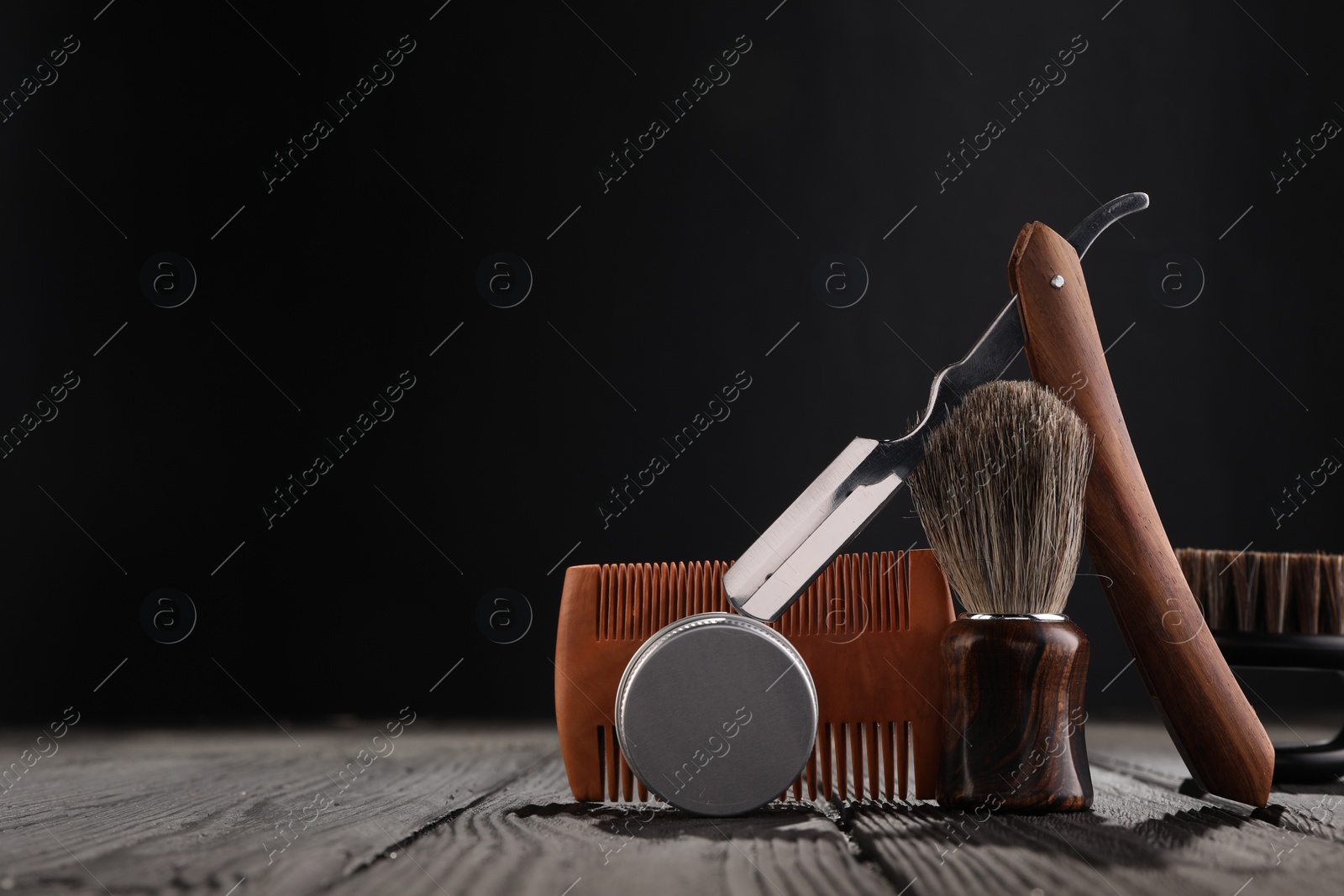 Photo of Moustache and beard styling tools on wooden table. Space for text