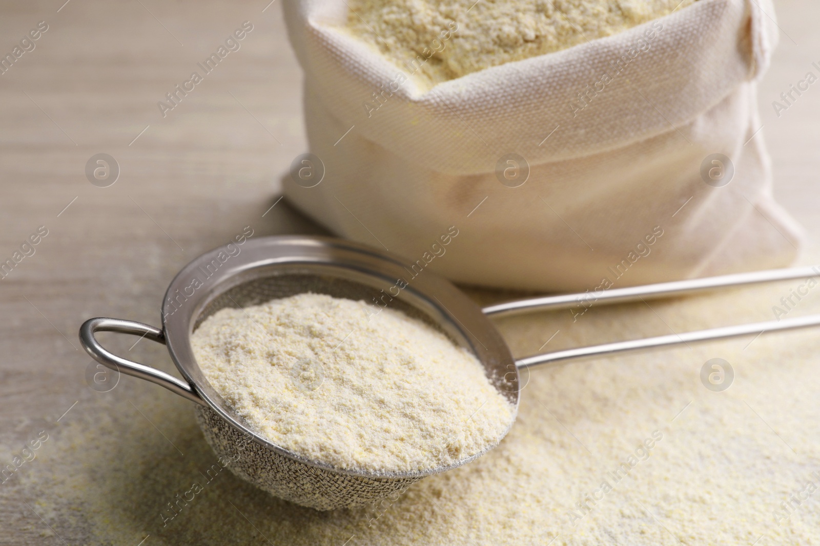 Photo of Sieve with quinoa flour on wooden table, closeup