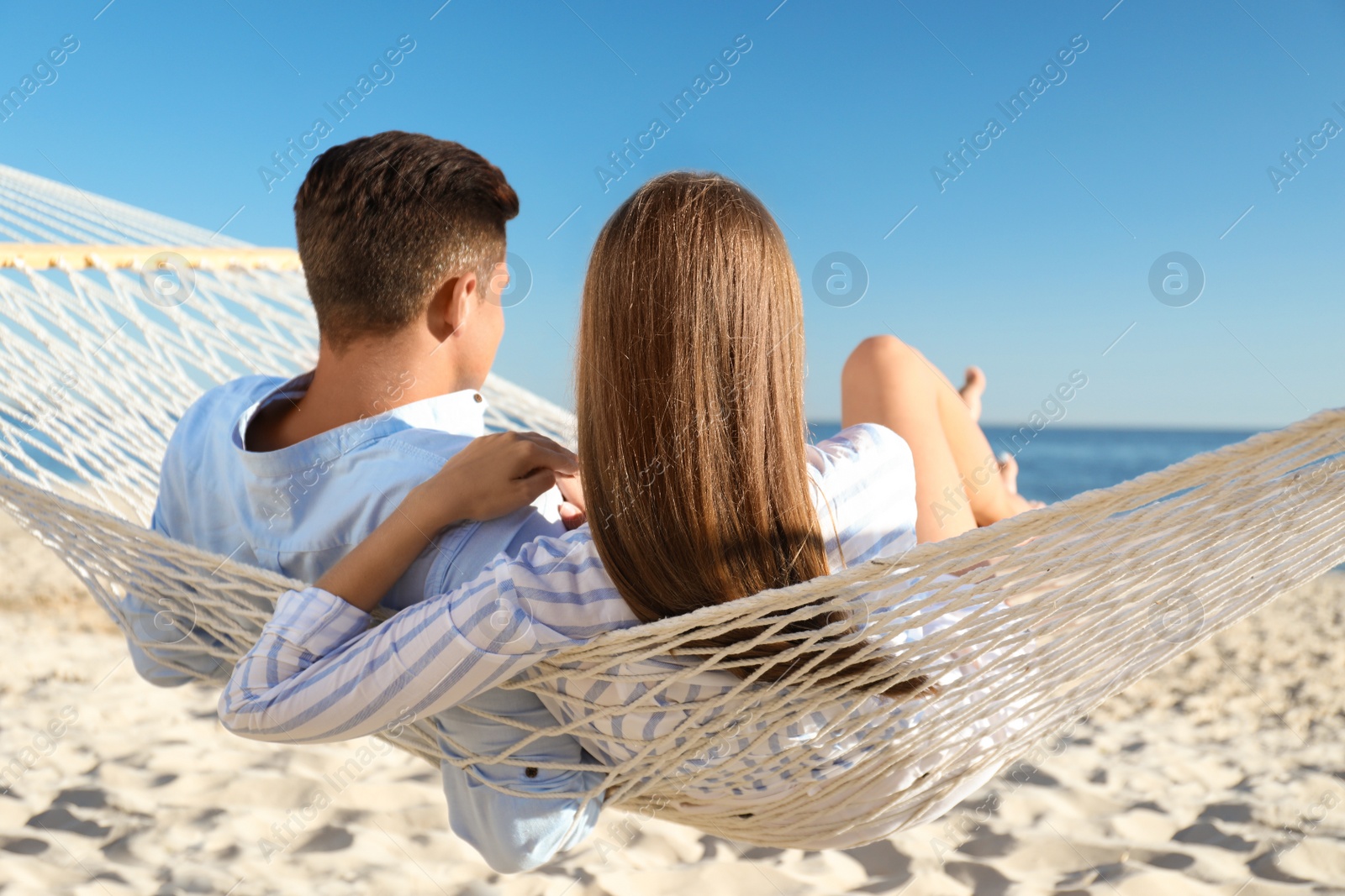 Photo of Couple relaxing in hammock on beach. Summer vacation